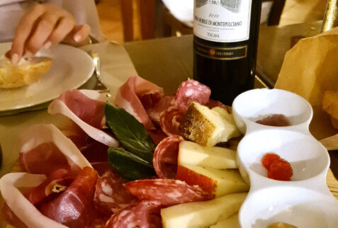 Plate of typical tuscan charcuterie and Nobile Montepulciano wine - Osteria del Borgo